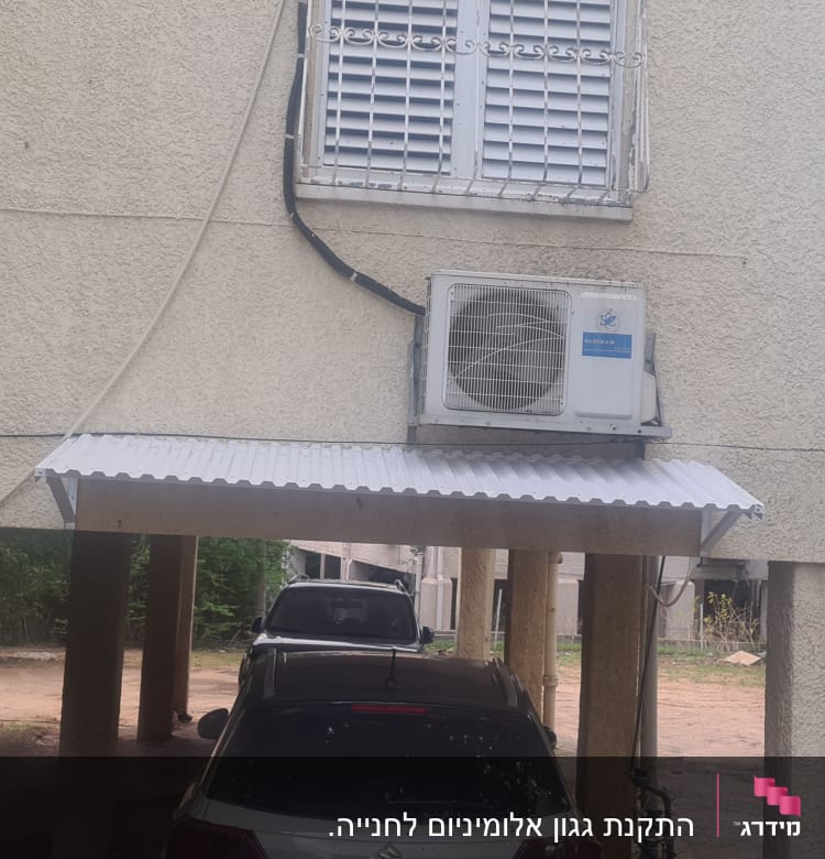 גגון אלומיניום מעל חניה עם מזגן מותקן על הקיר